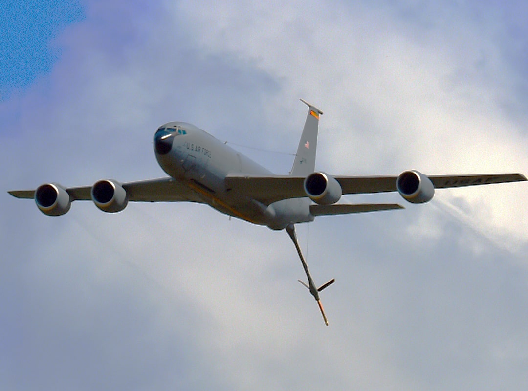 U.S. Air Force KC-135 Stratotanker aerial refueling aircraft in flight, shown from below with refueling boom extended against a cloudy sky.